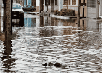 a City Street Submerged in Floodwater, with Parked Cars Along the Curb and Buildings Reflected in the Water. › La Sierra Madre