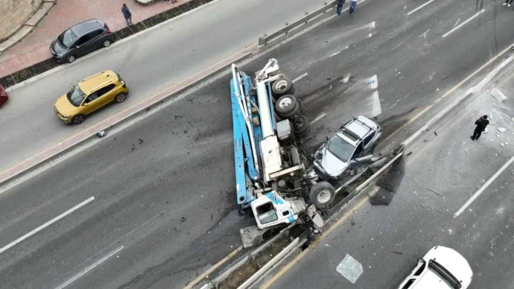 Overhead View of a Overturned Blue Truck Resting on a Median Barrier After a Highway Crash, with a Damaged White Car Wedged Between the Truck and Guardrail. › La Sierra Madre