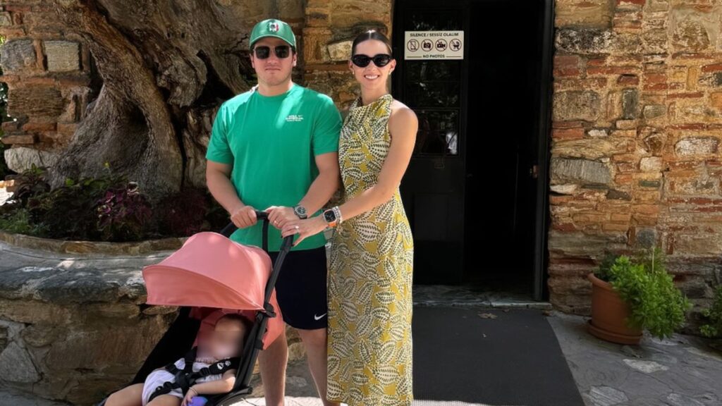 Critican-viajes-samuel-garcia-modo-party › La Sierra Madre Couple Posing with a Baby in a Pink Stroller Outside a Stone Building; Man in Green Shirt and Cap, Woman in a Yellow Patterned Dress Wearing Sunglasses. › La Sierra Madre